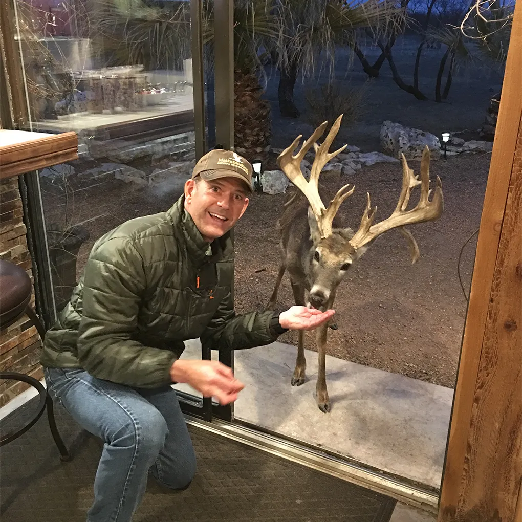 A hunter with an exotic buck taken on the ranch