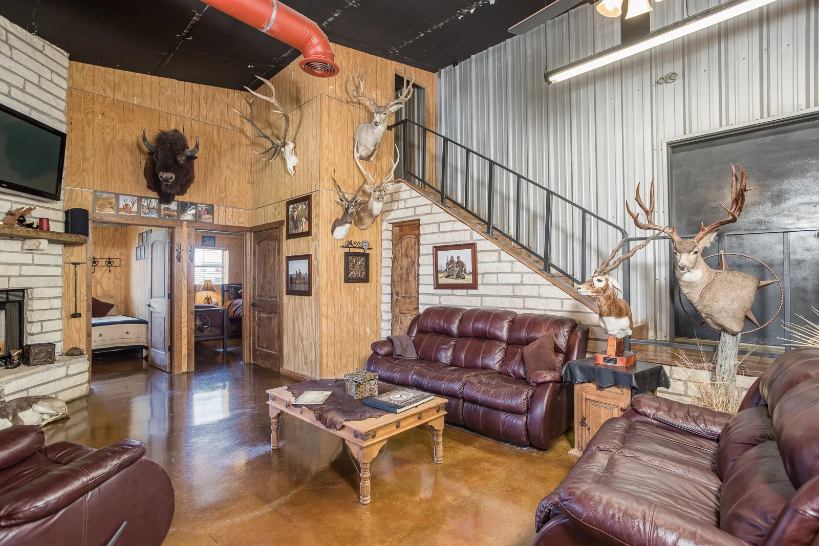 The lodge great room with leather seating, mounts and warm light